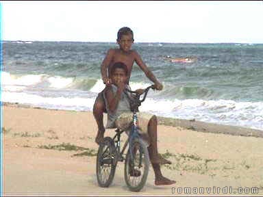 Kids trying out their bike on the beach at Jaipiritinga