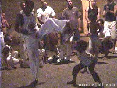 Kid taking on grownup at evening Capoeira