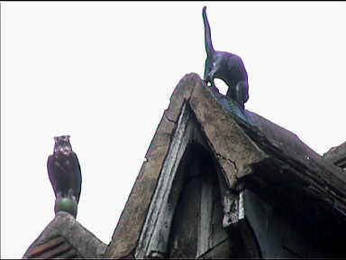 Decorative cat and owl on house roof
