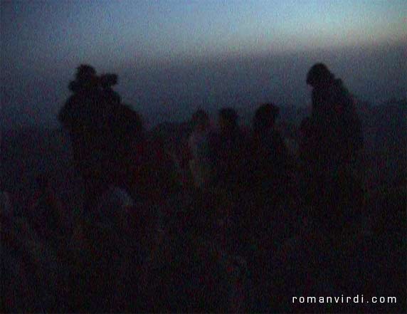 A whole load of cold tourists freezing while waiting for the sun to rise on the top of Mt. Moses. Bedouins will loan you a blanket for a small fee. The trek up Mount Moses starts in the middle of the night. Camel drivers wait at the bottom of the mountain and pester you to take a camel. Fortunately, the steepest part of the trek at the top of the mountain cannot be made by camel