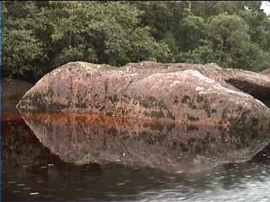 Huge, strange rock reflecting in the river