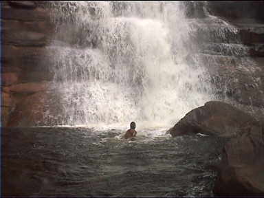 Swimming in Angel Falls lagoon. Here you can see the approximate amount of water coming down from the falls. Swimming in the falls is Alex, our guide